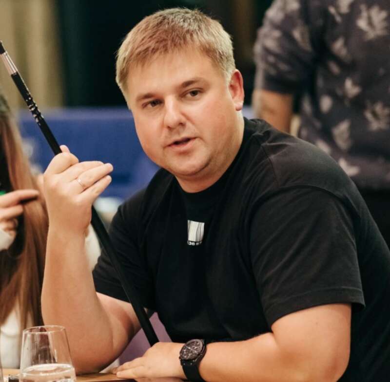 Dnipro resident Maksym Filipovskyi wearing a black T-shirt sitting at a table